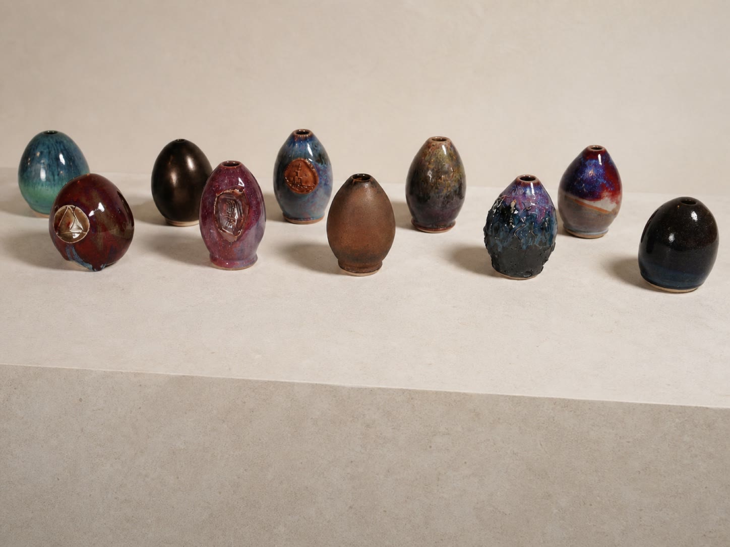 A collection of small egg-shaped glazed ceramic forms