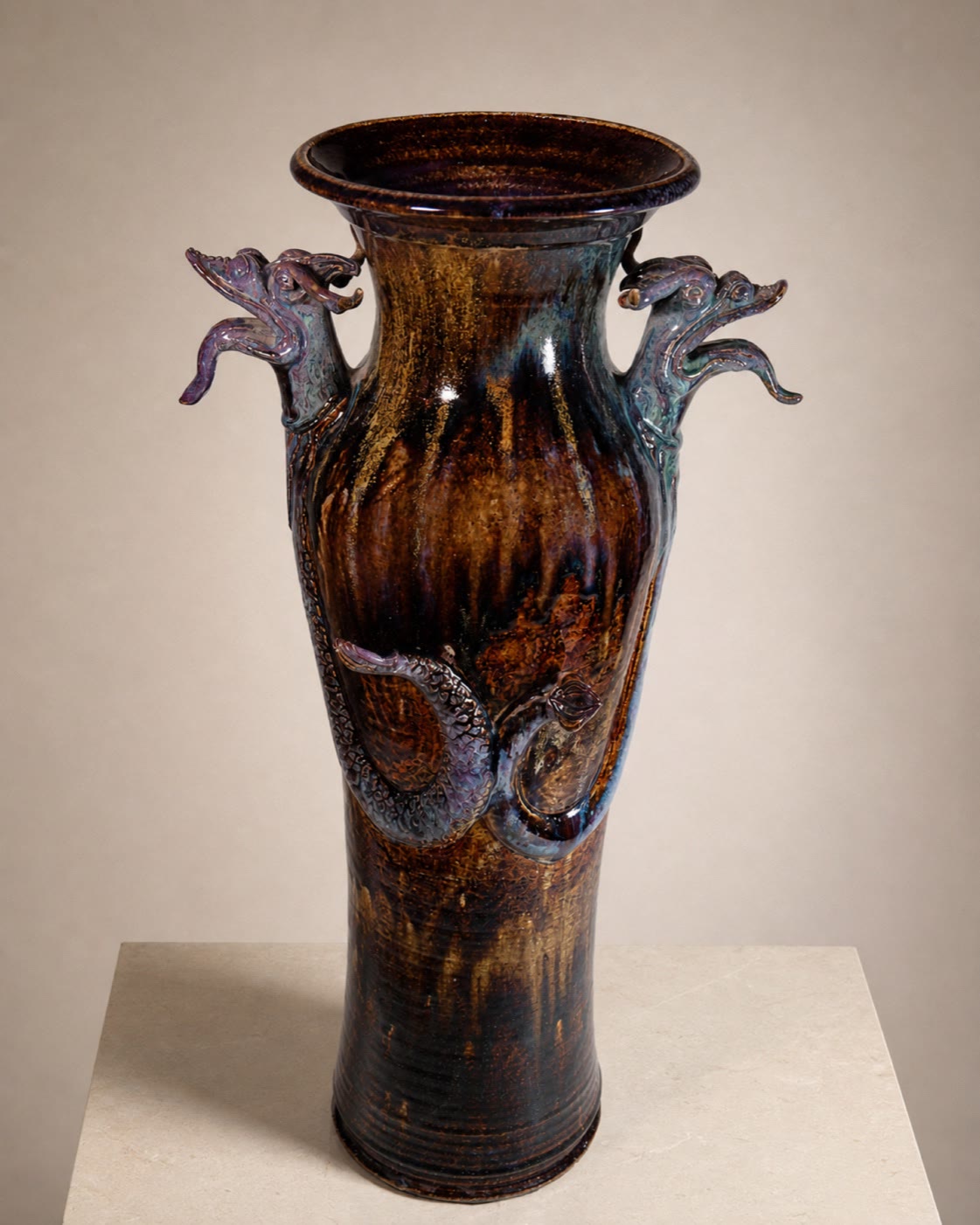 A tall brown glazed sculptural ceramic urn