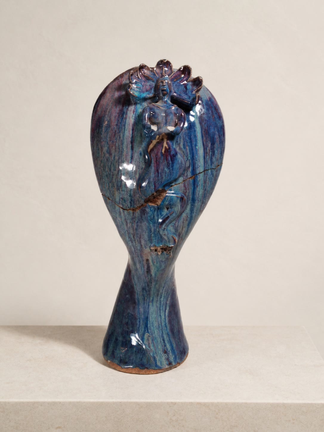 A tall blue sculptural ceramic vessel