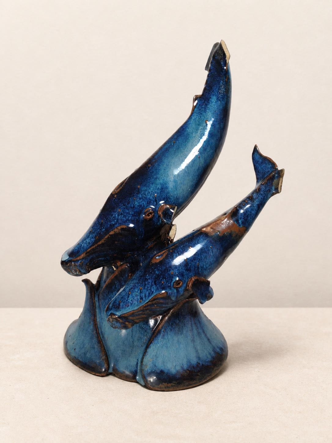 A deep-blue ceramic sculpture of two whales