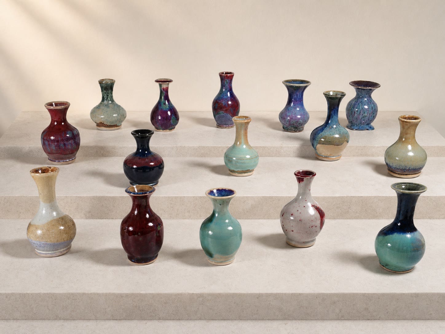 A large collection of small colorful ceramic vases